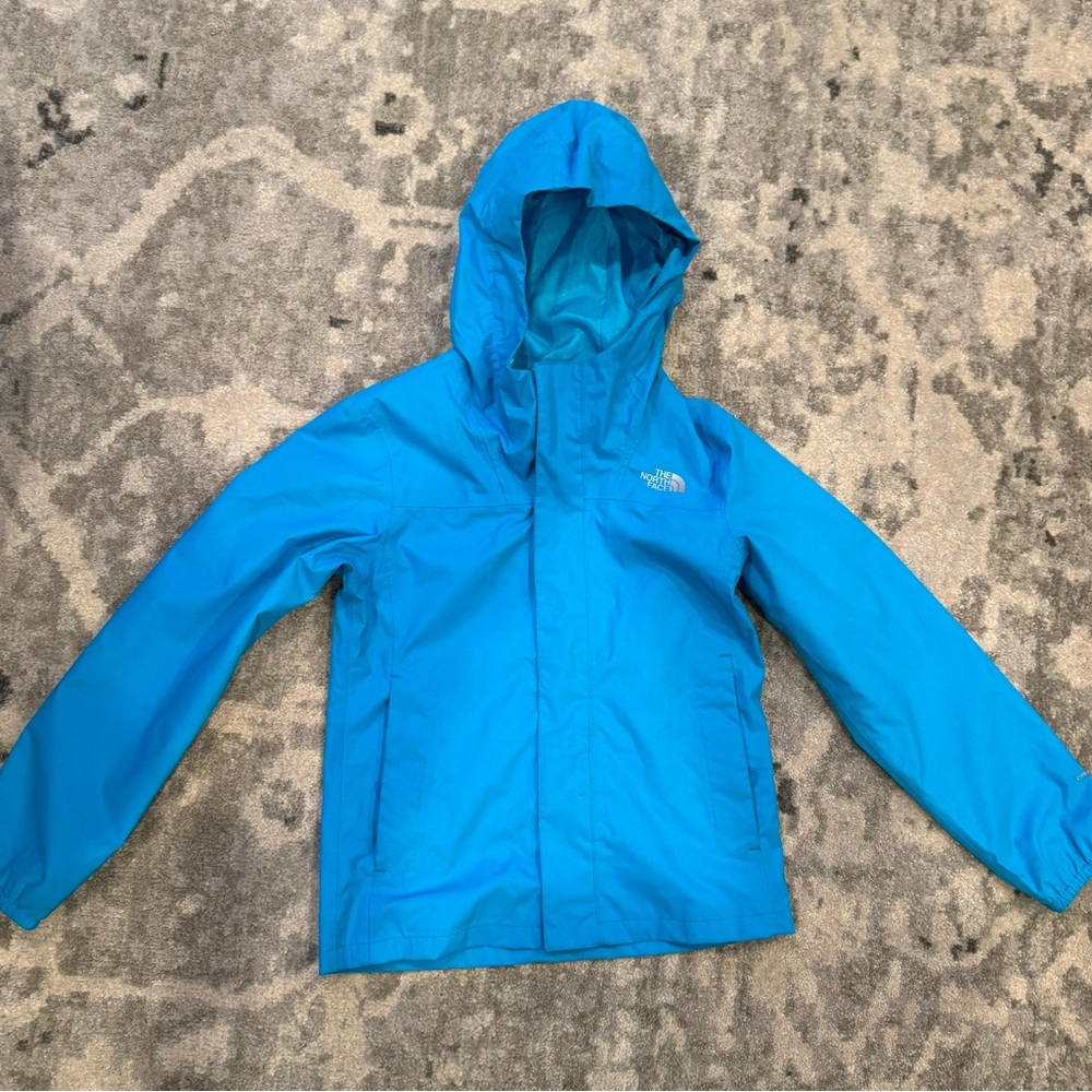 The NorthFace girlsshell jacket in blue/teal with hood.
